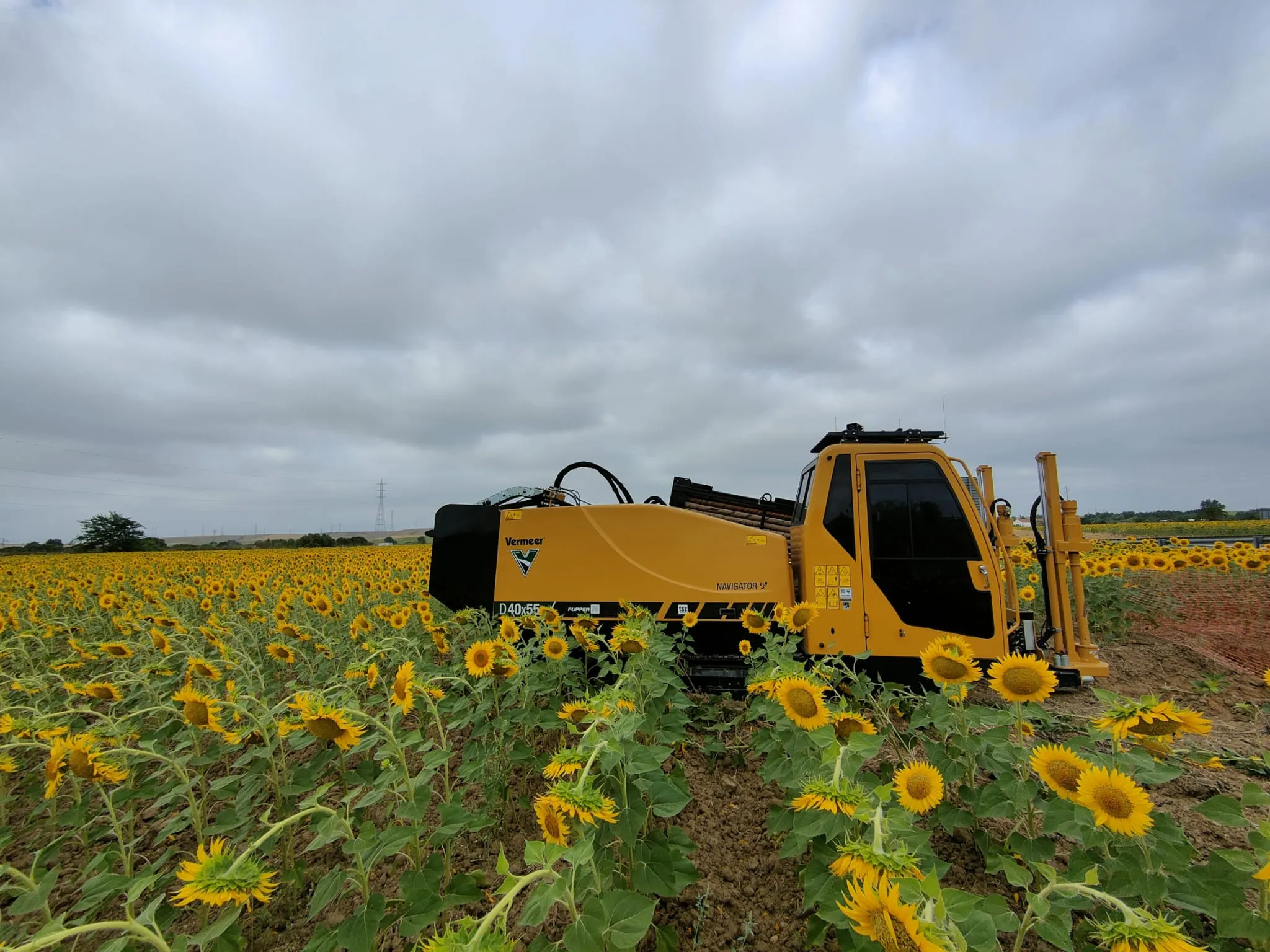Perforadora Vermeer HDD al atardecer con aerogeneradores de fondo